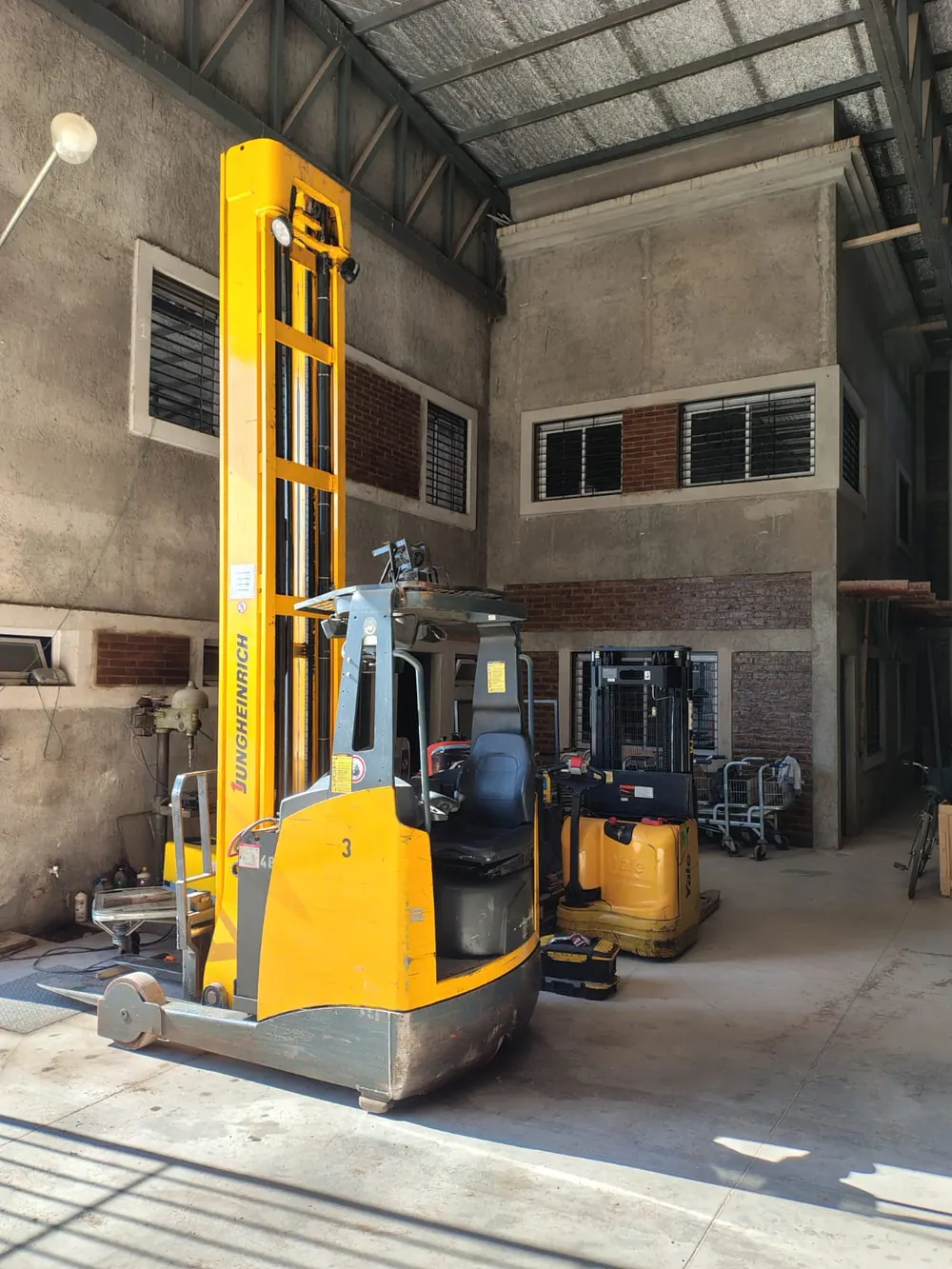 Autoelevador retráctil trabajando dentro de un depósito