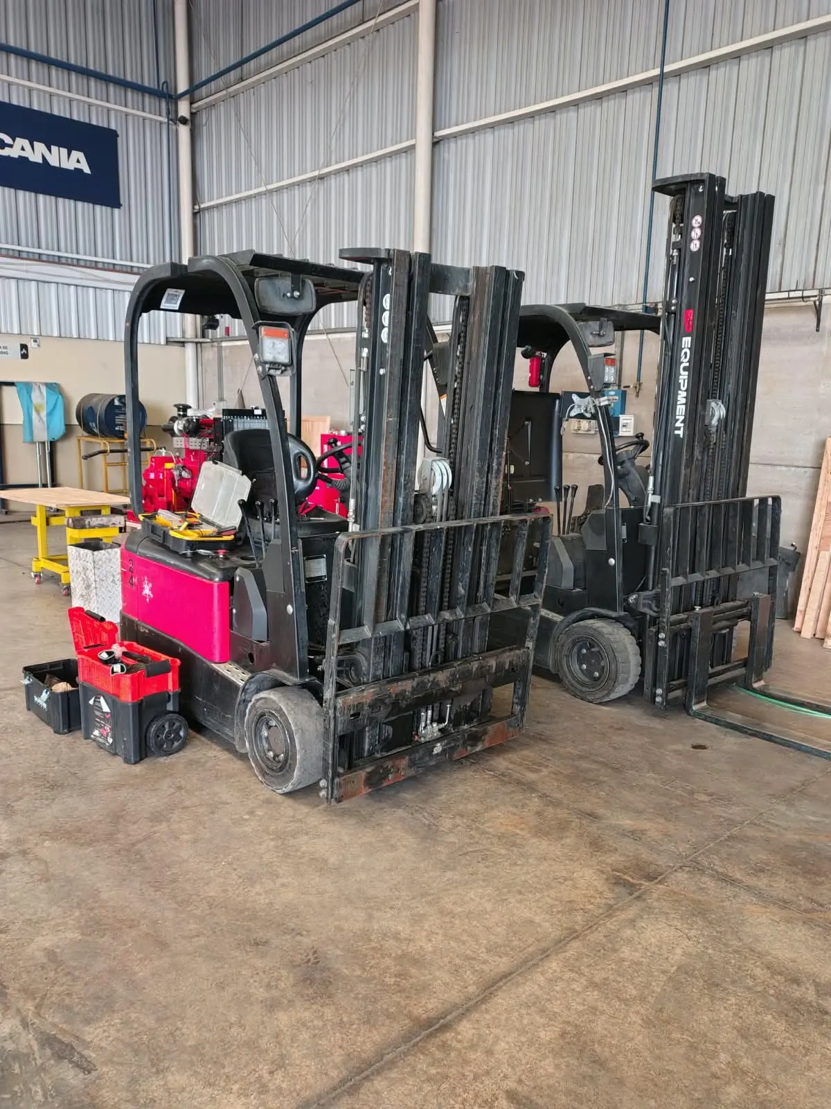 Autoelevadores eléctricos en un galpón, con cajas de herramientas para el servicio técnico